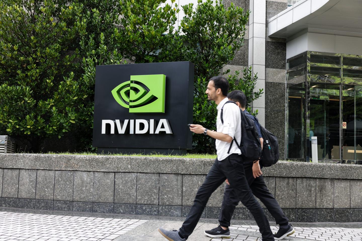 people walk by Nvidia sign