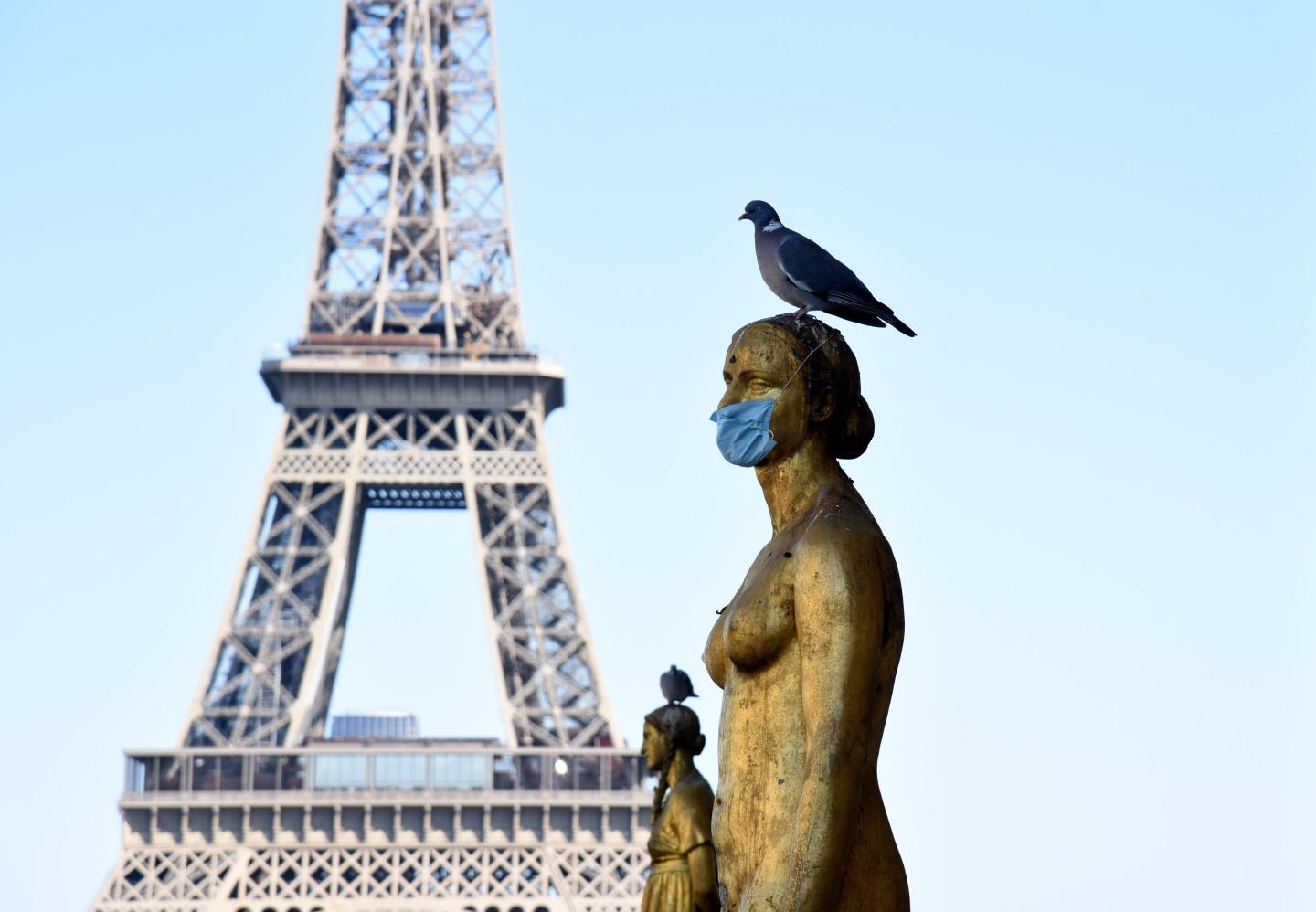 Paris (France) on May 17, 2020: statue in 'Place du Trocadero' square with a protective mask against Coronavirus, Covid19, and the Eiffel Tower in the background.