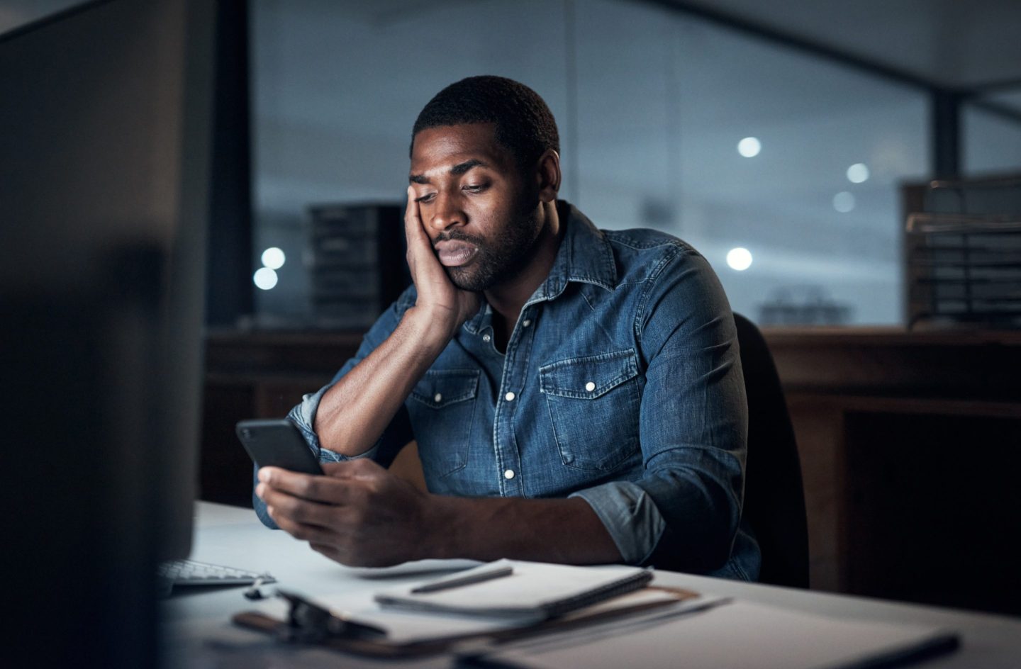 Young man working at his desk in an office at night