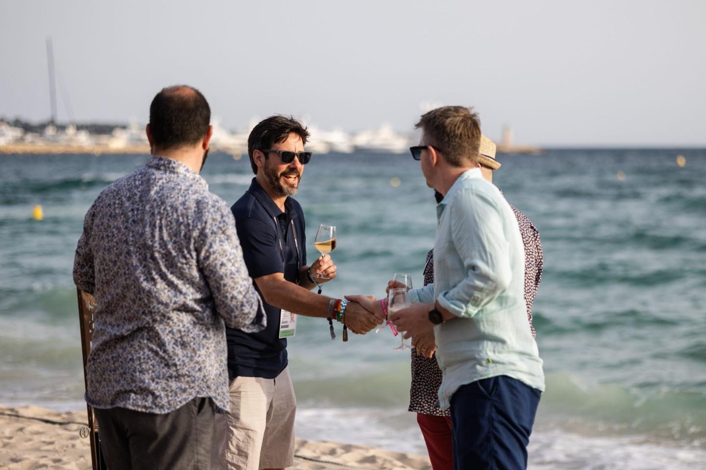 A group of executives networking and drinking on the beach at Cannes.