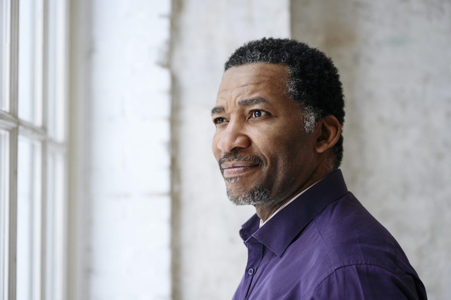 Photo of a mature man looking out a window