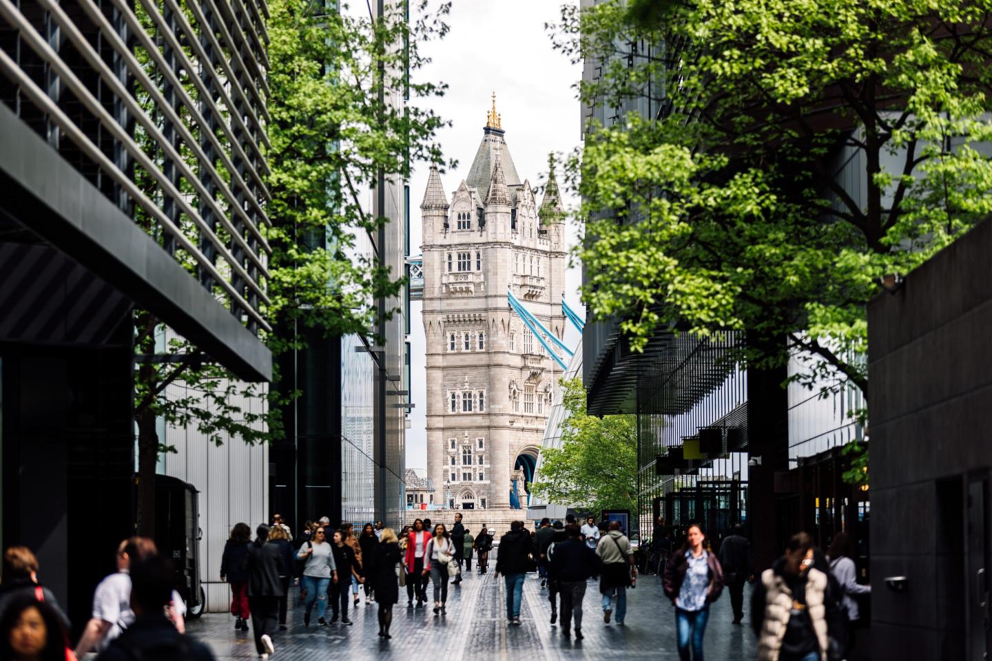 Tower Bridge in London is seen through the facades of modern office buildings