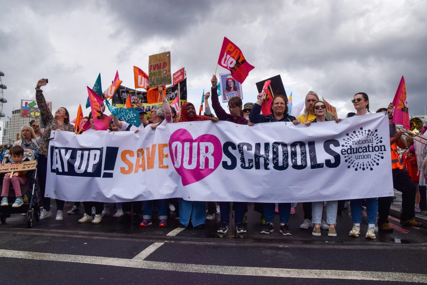 a group of people holding up a banner at a teachers' strike