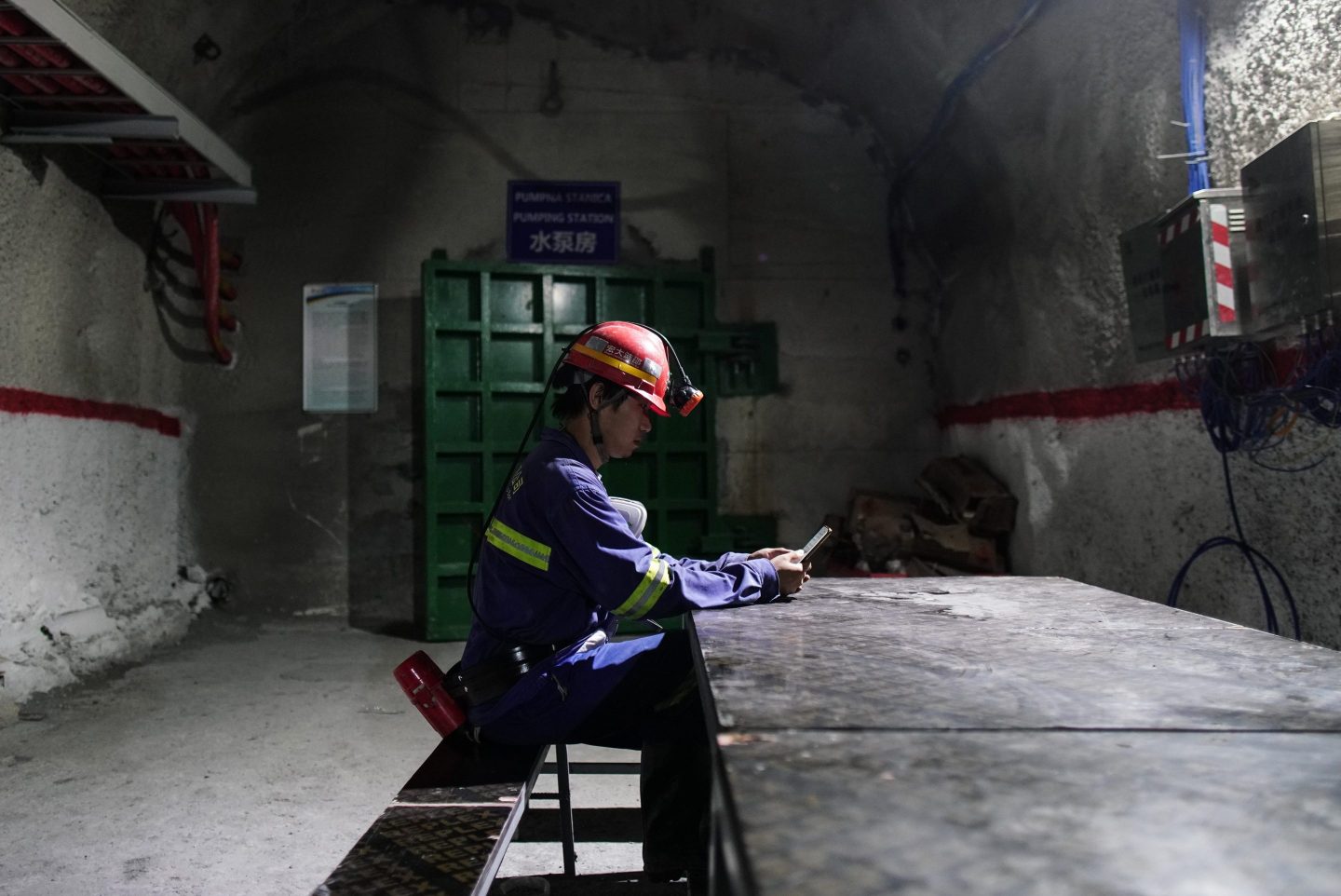 A miner browses a smartphone in a rest room underground at the Cukaru Peki copper and gold mine, operated by Zijin Mining Group Co., in Bor, Serbia, on Friday, Aug. 25, 2023.
