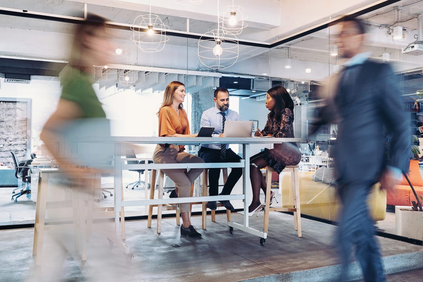 Group of colleagues sitting and working together in a busy office.