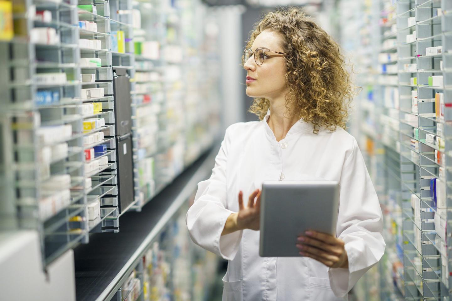 Blonde woman walking down pharmacy aisles