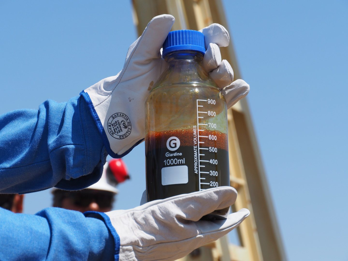 person holding a bottle of crude oil