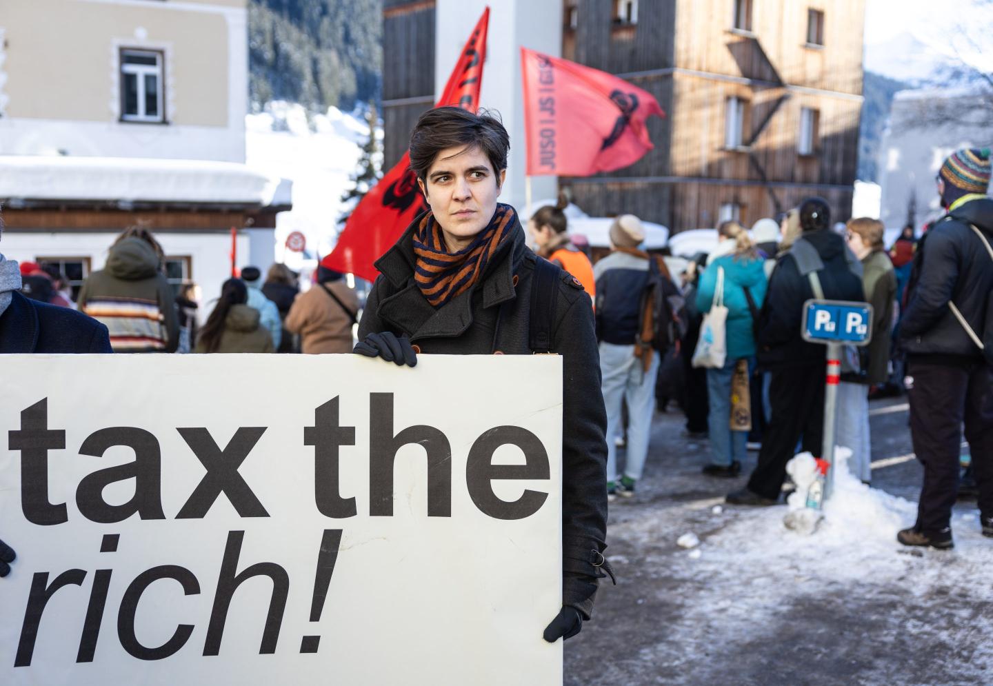 Marlene Engelhorn holding up a board that says "tax the rich"