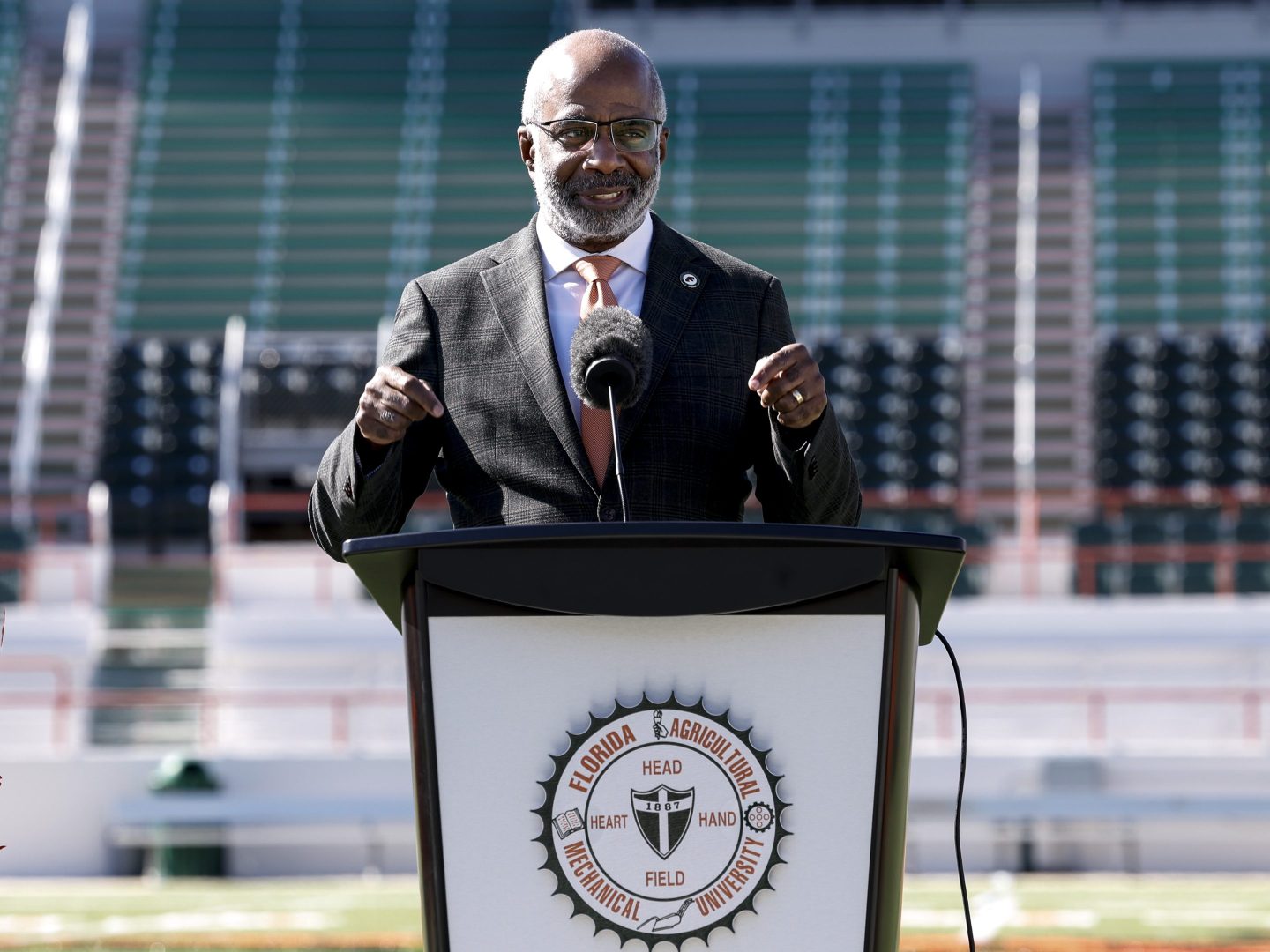 Florida A&M President Larry Robinson stands at a podium on the schools football field