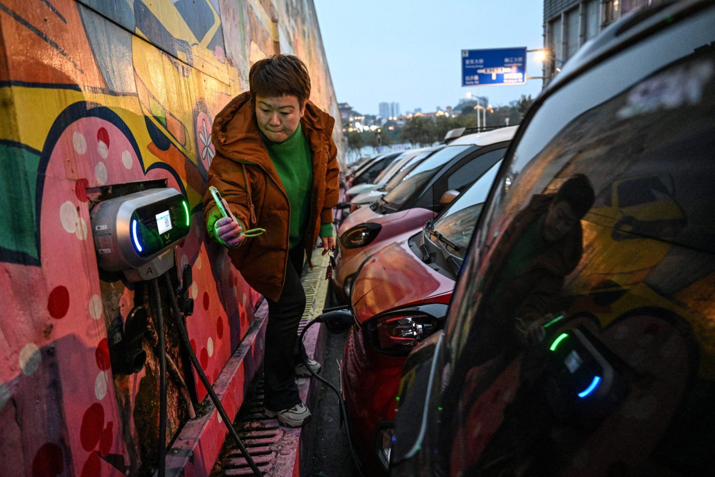A female driver in China scanning a code to charge her electric car in Liuzhou, in southern China's Guangxi province.
