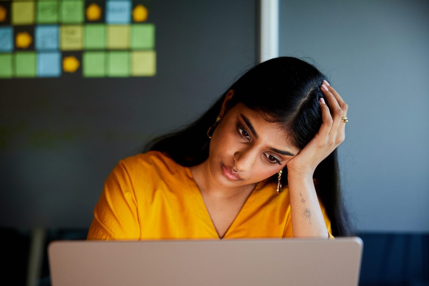 Worker is stressed at laptop.