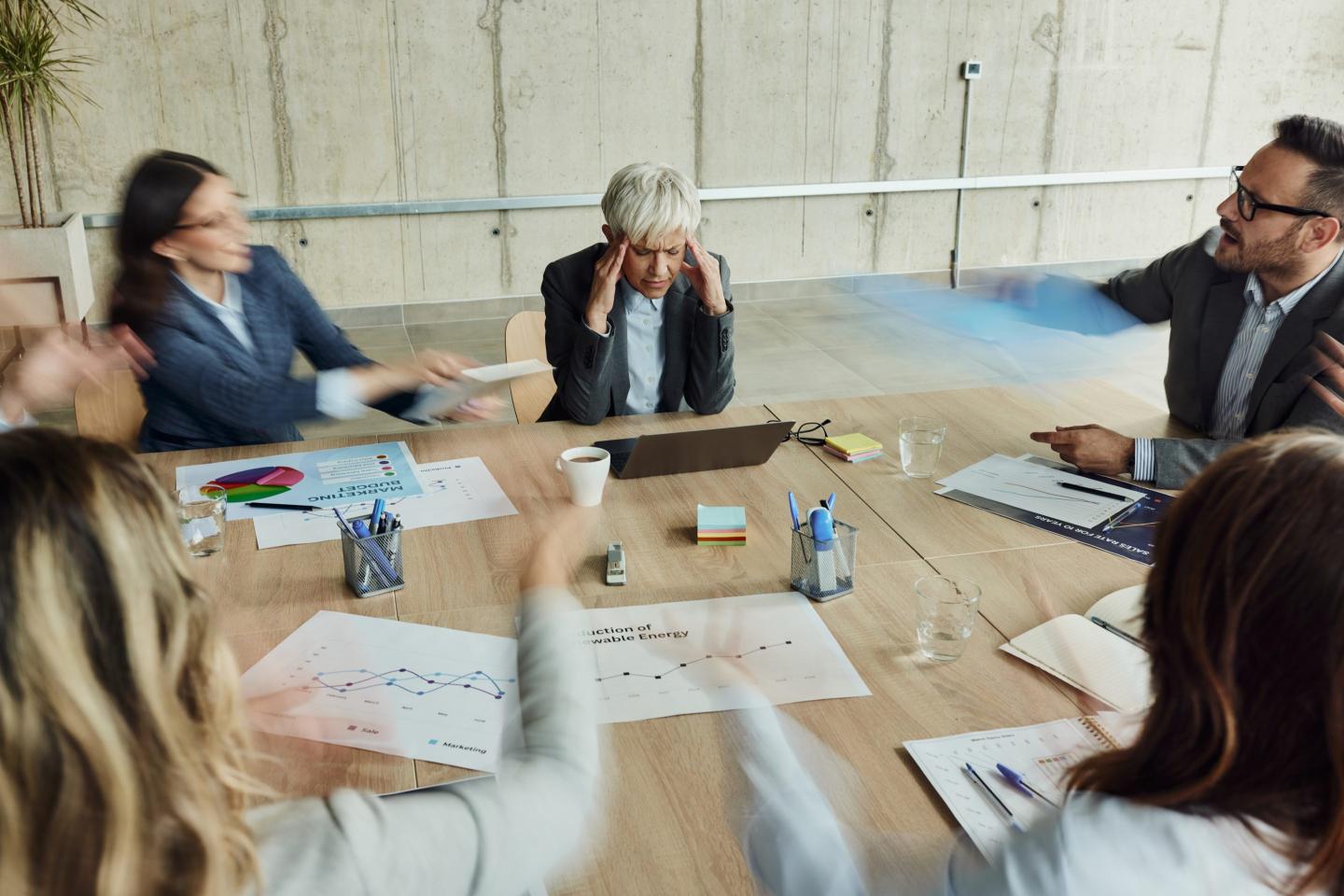 people in a frantic discussion around a table