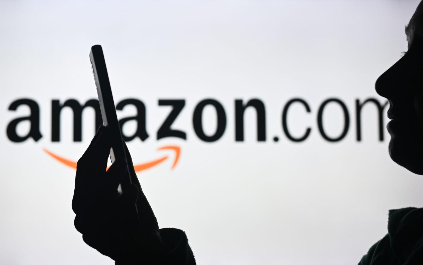 Customer on phone app in front of Amazon logo.