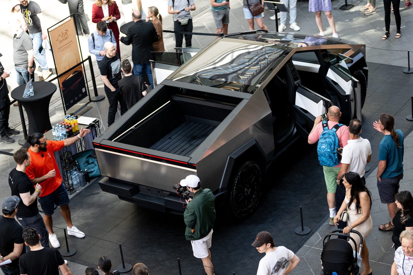02 May 2024, Berlin: People stand around the Cybertruck at the launch of "The Cyber Odyssey" at the Mall of Berlin.