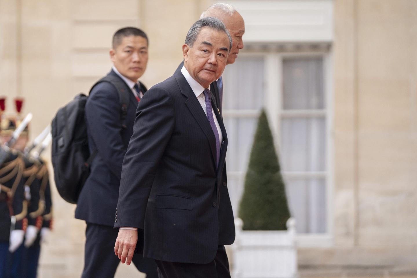 Chinese foreign minister Wang Yi looks over his should as he walks with aides.