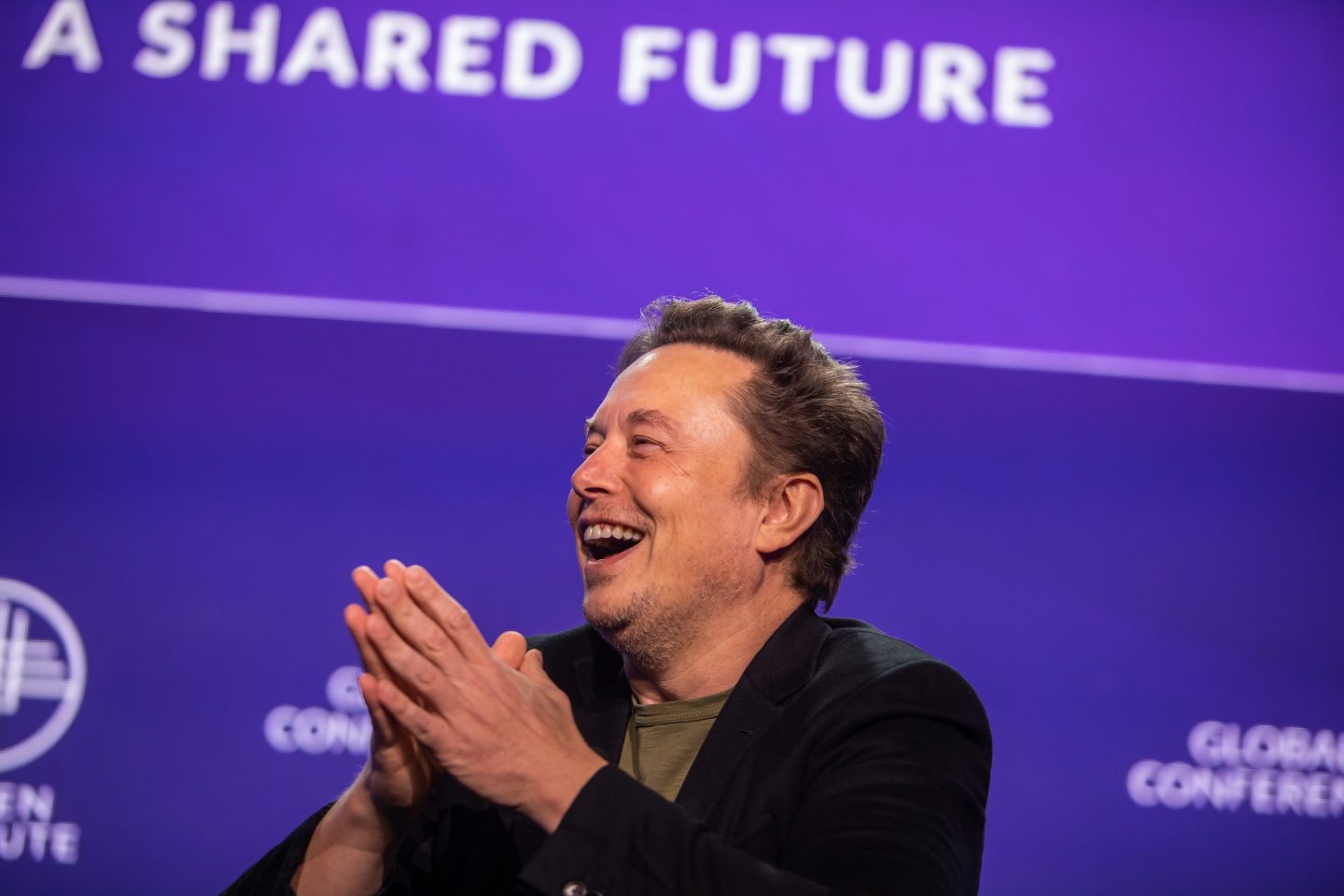 Elon Musk laughing at a conference in May