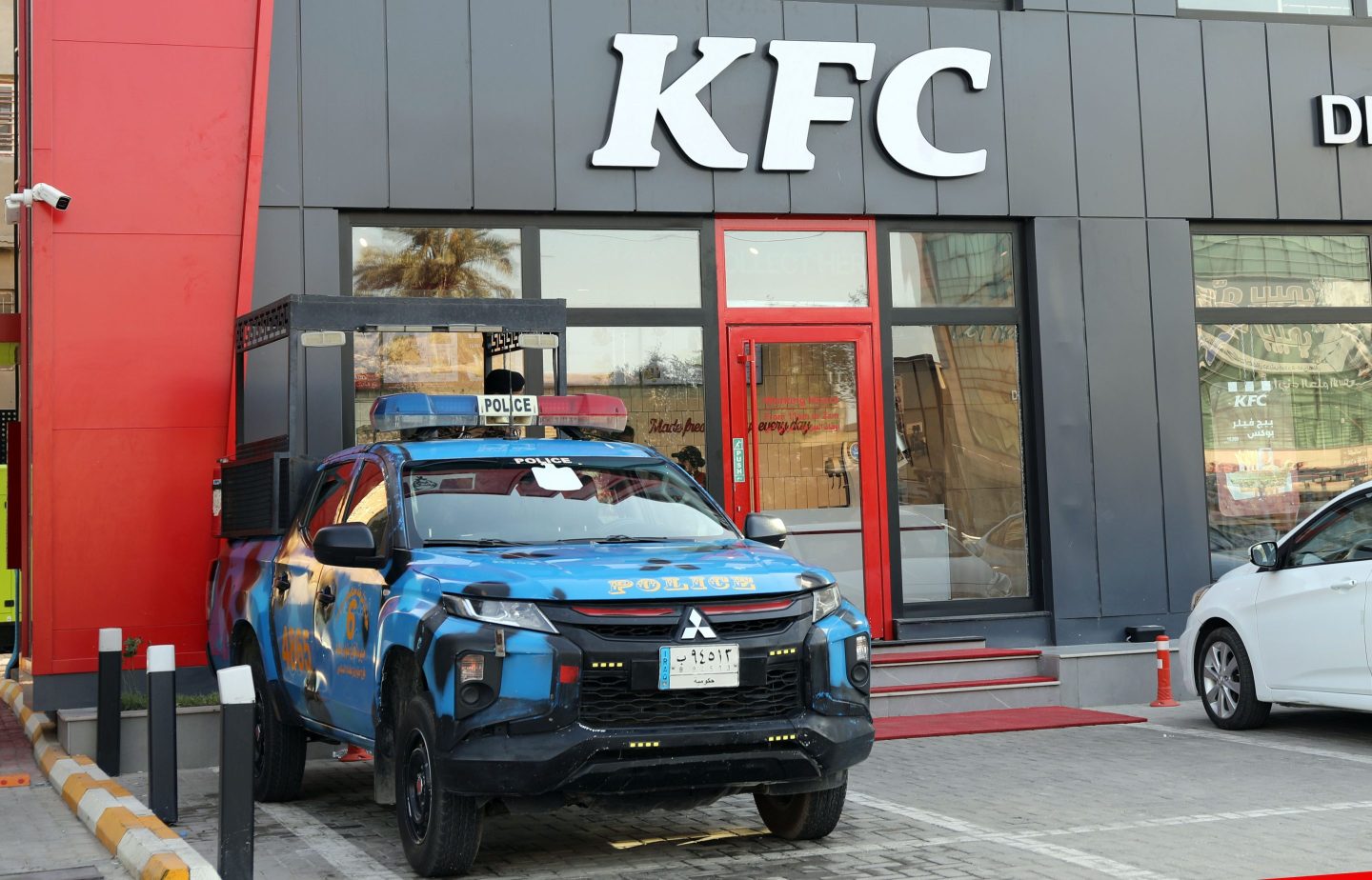 An Iraqi police vehicle is seen in front of a KFC restaurant in Baghdad, Iraq