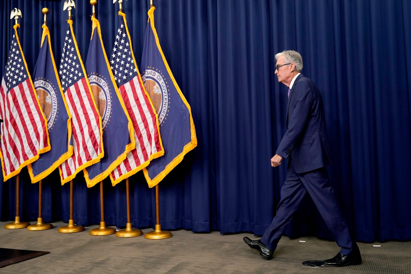Jerome Powell walks toward flags