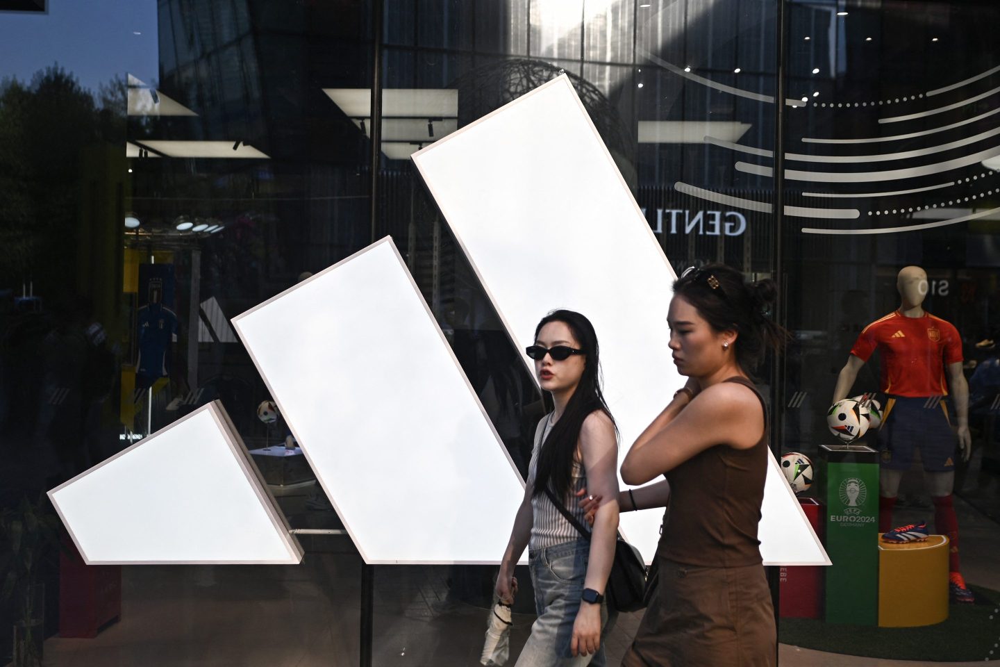 People walk past an Adidas store at a mall in Beijing.