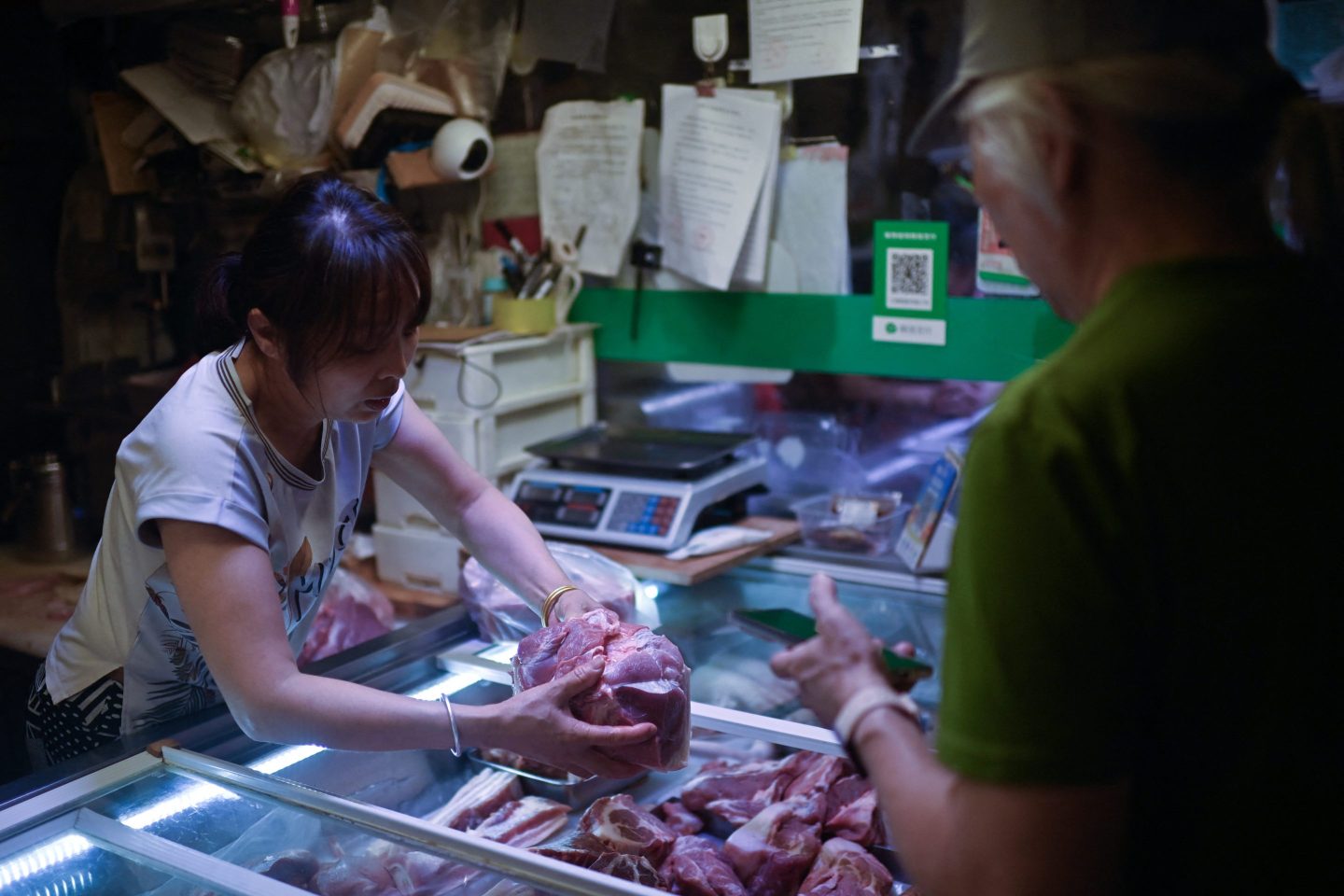 A butcher sells pork meat at a store in Beijing on June 17, 2024.