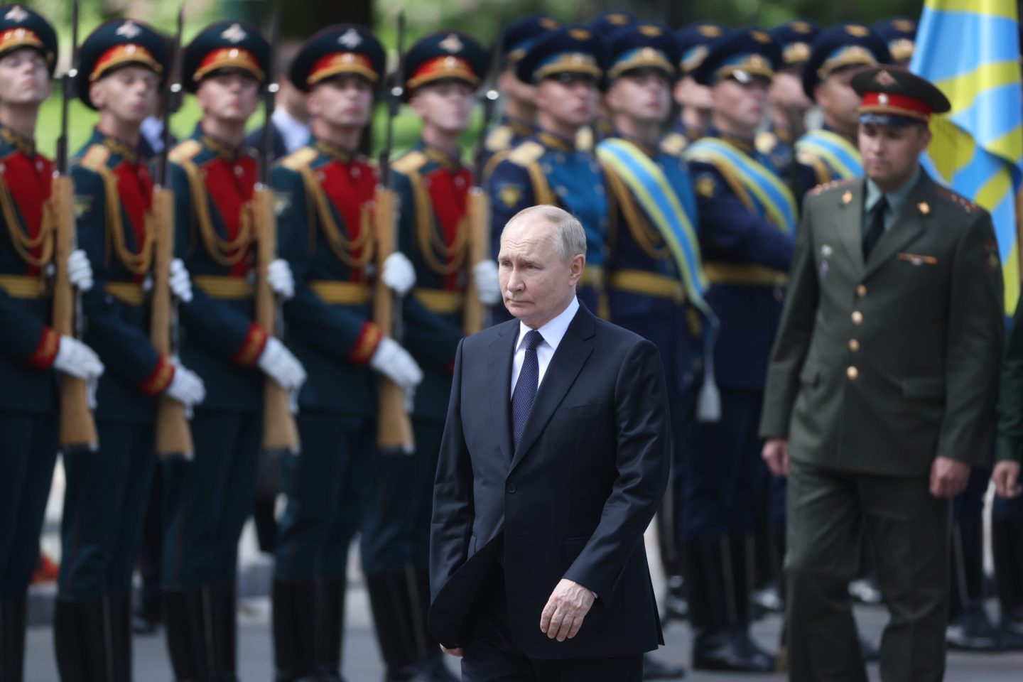 Vladimir Putin walks by row of soldiers