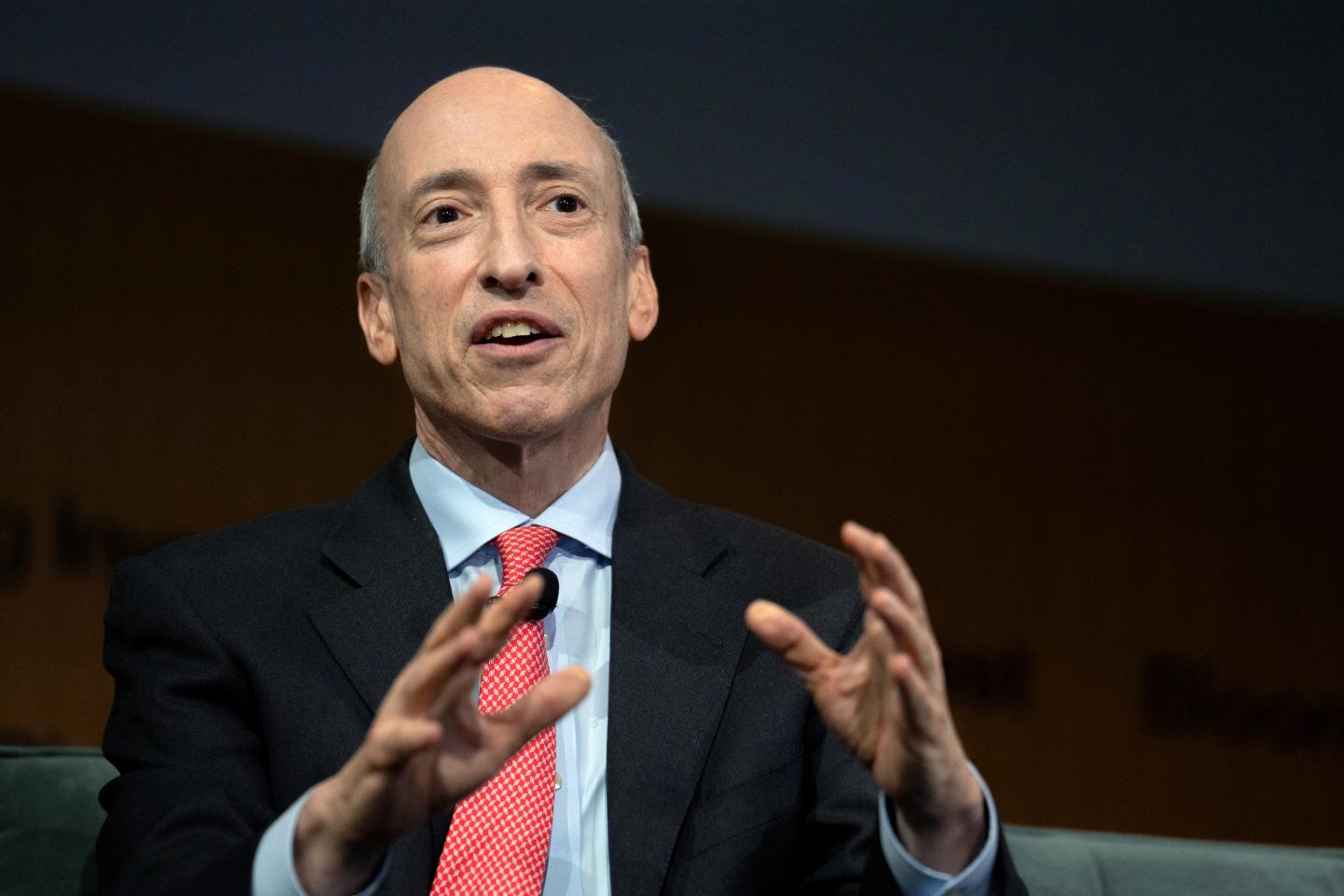 CFTC chairman Gary Gensler gestures with both hands while looking into the distance as he speaks.