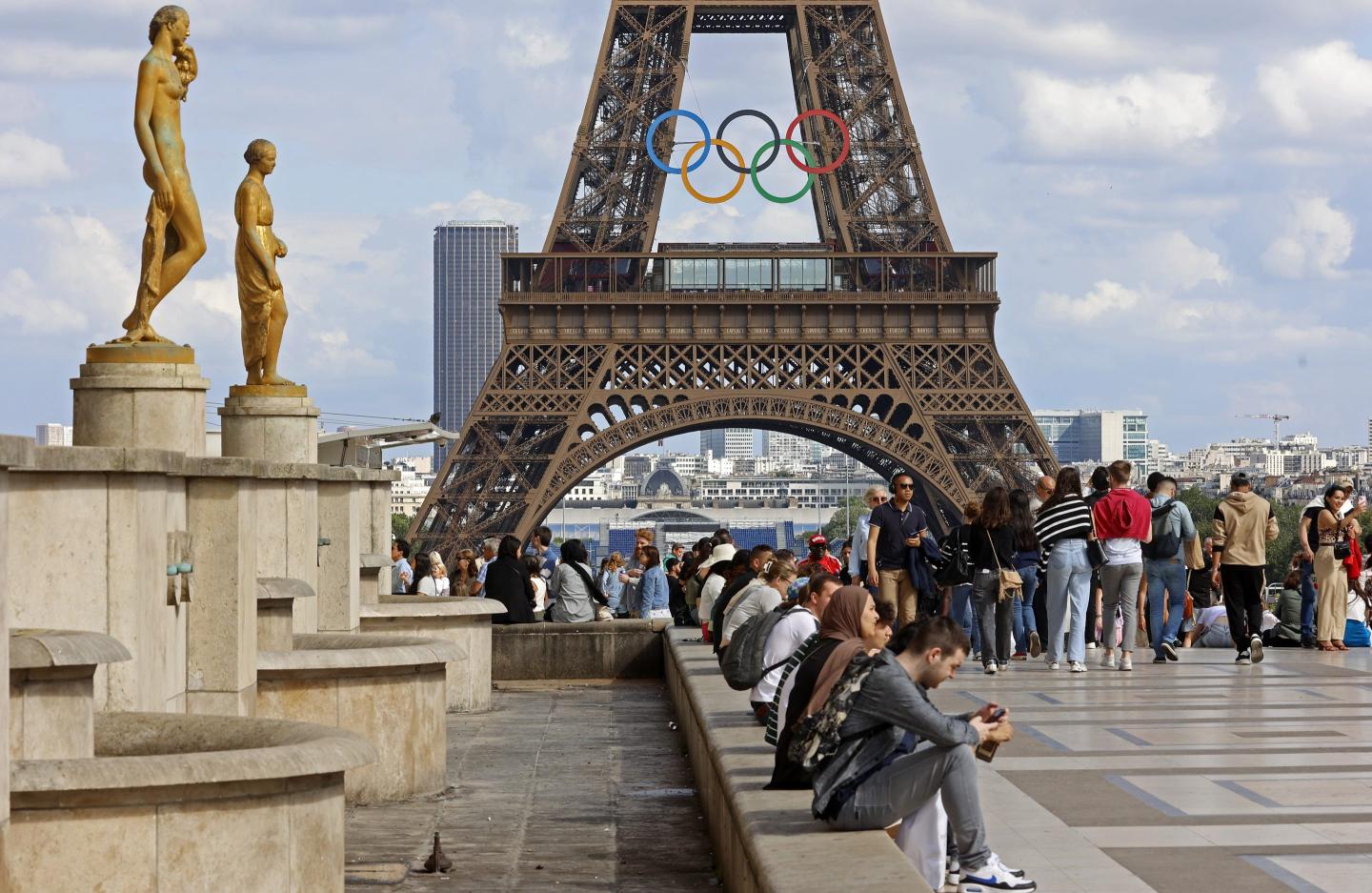 Crowds of Tourists rest in front of the Eiffel Tower