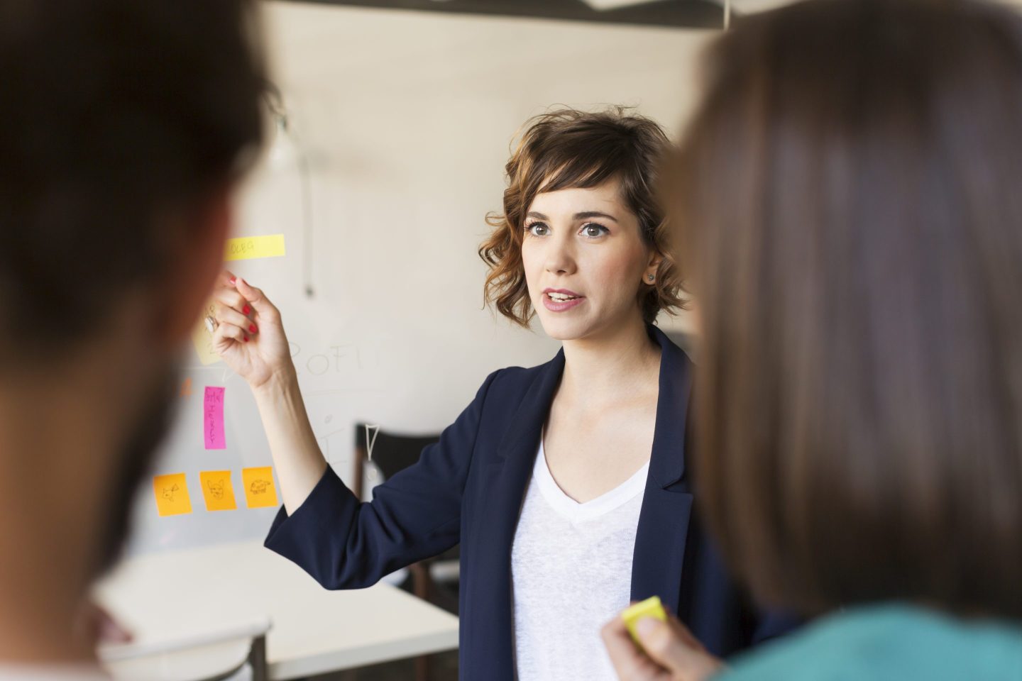 Businesswoman explaining presentation to colleagues in office