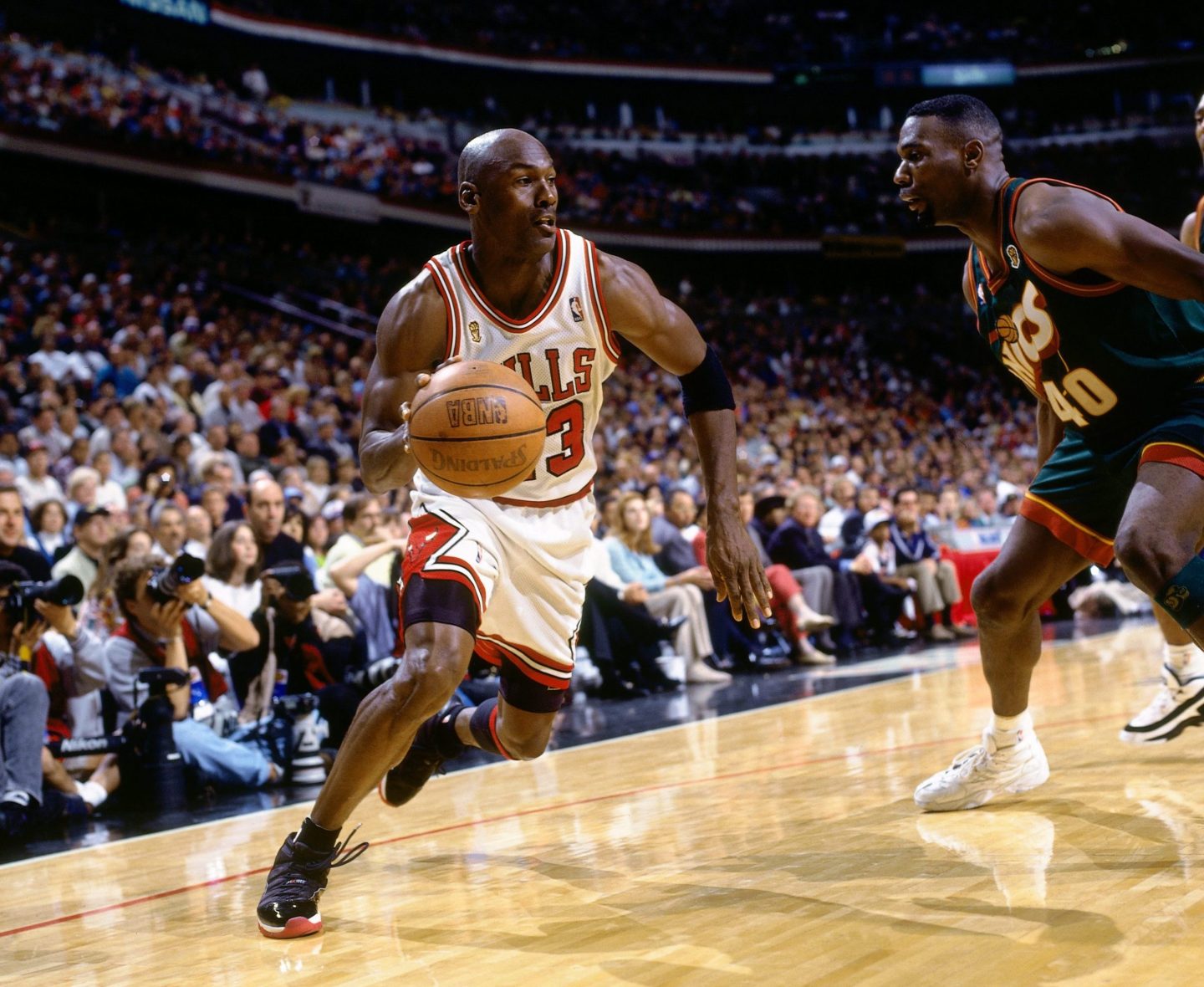 Michael Jordan dribbling a basketball as he is guarded by Shawn Kemp