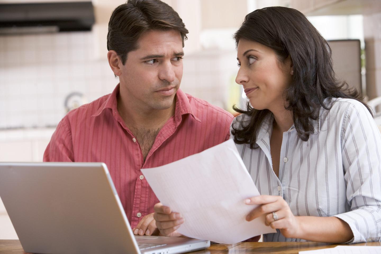 worried couple looking at bills