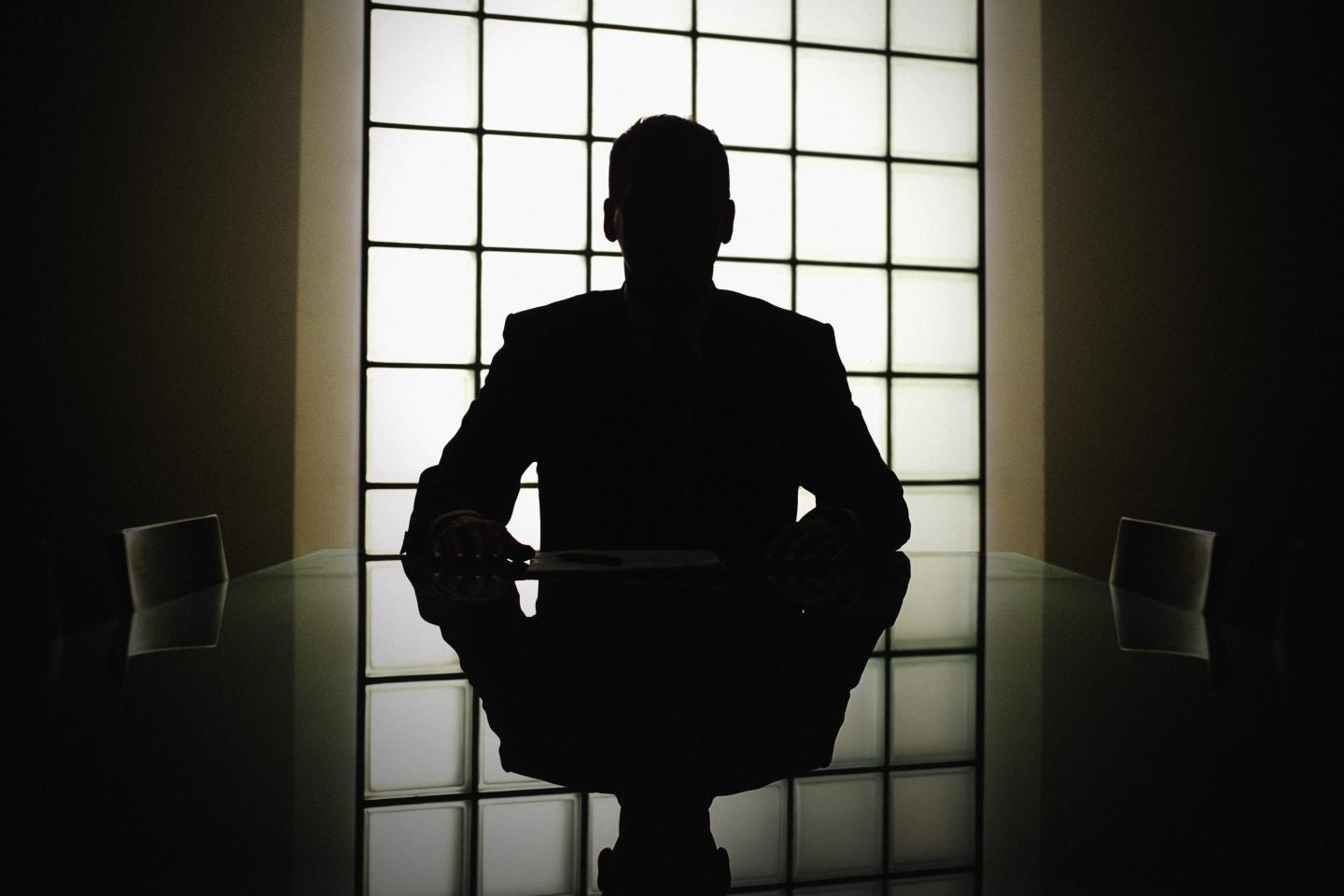 Silhouette of a man at a desk