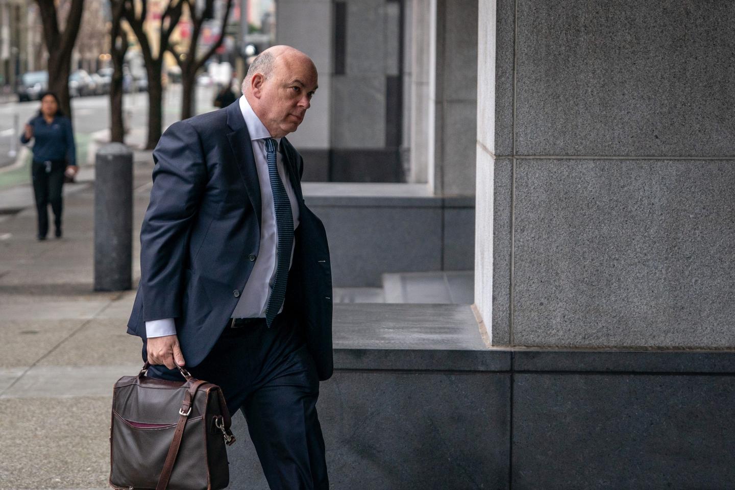 Mike Lynch arrives in court alone, carrying a briefcase