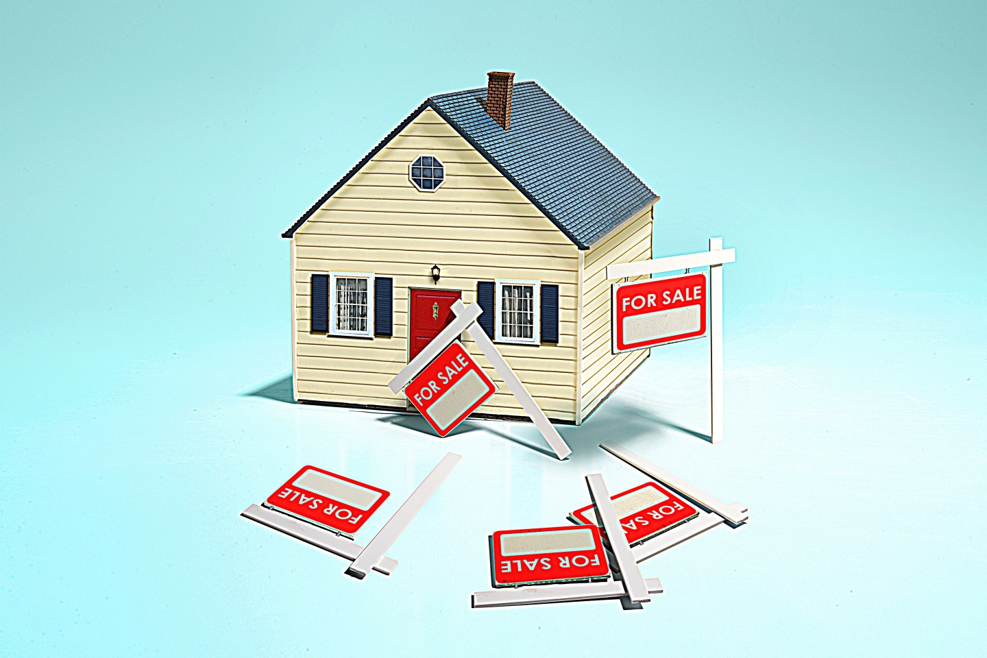 Photo illustration by C.J. Burton — Getty Images
A house on a blue background has many for sale signs laying around in front of it.