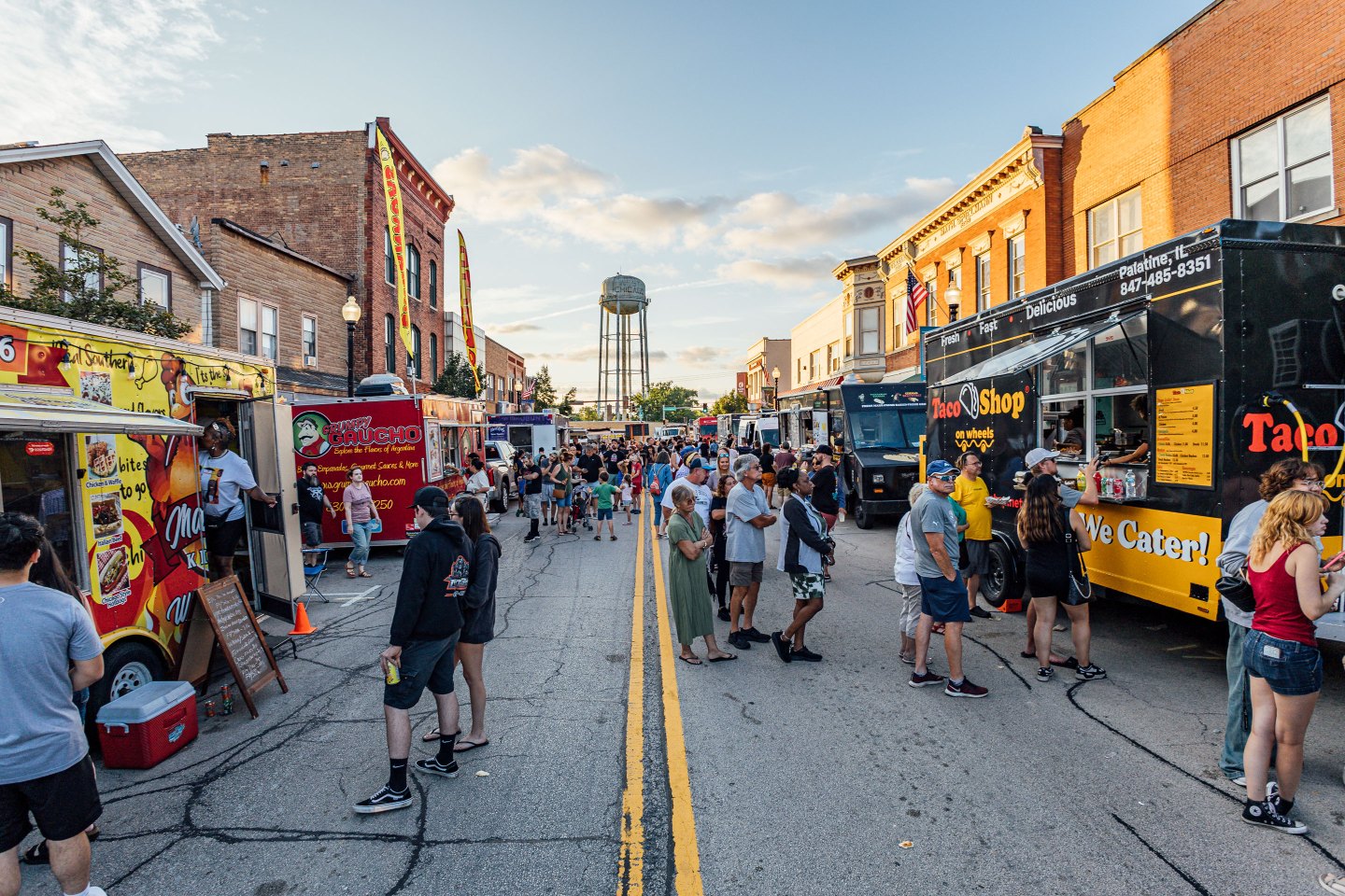 Event-goers savor a summer evening with food trucks lining Main Street at the West Chicago Food Festival.