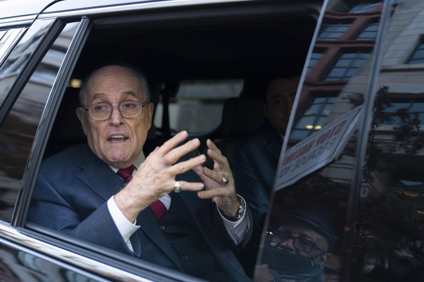 Rudy Giuliani talks to reporters as he leaves after his defamation trial in Washington, Dec. 15, 2023.