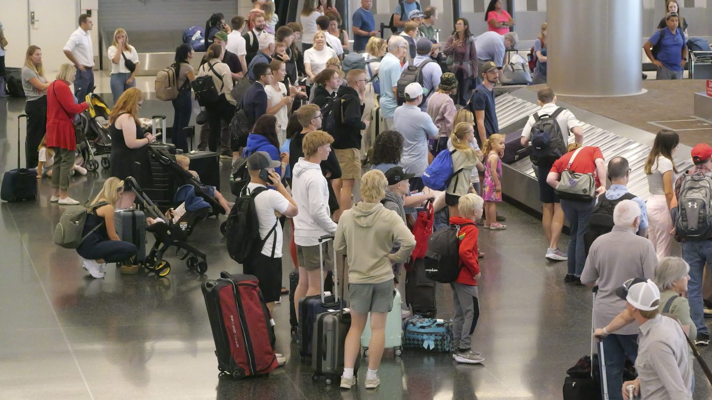 travelers wait for their luggage