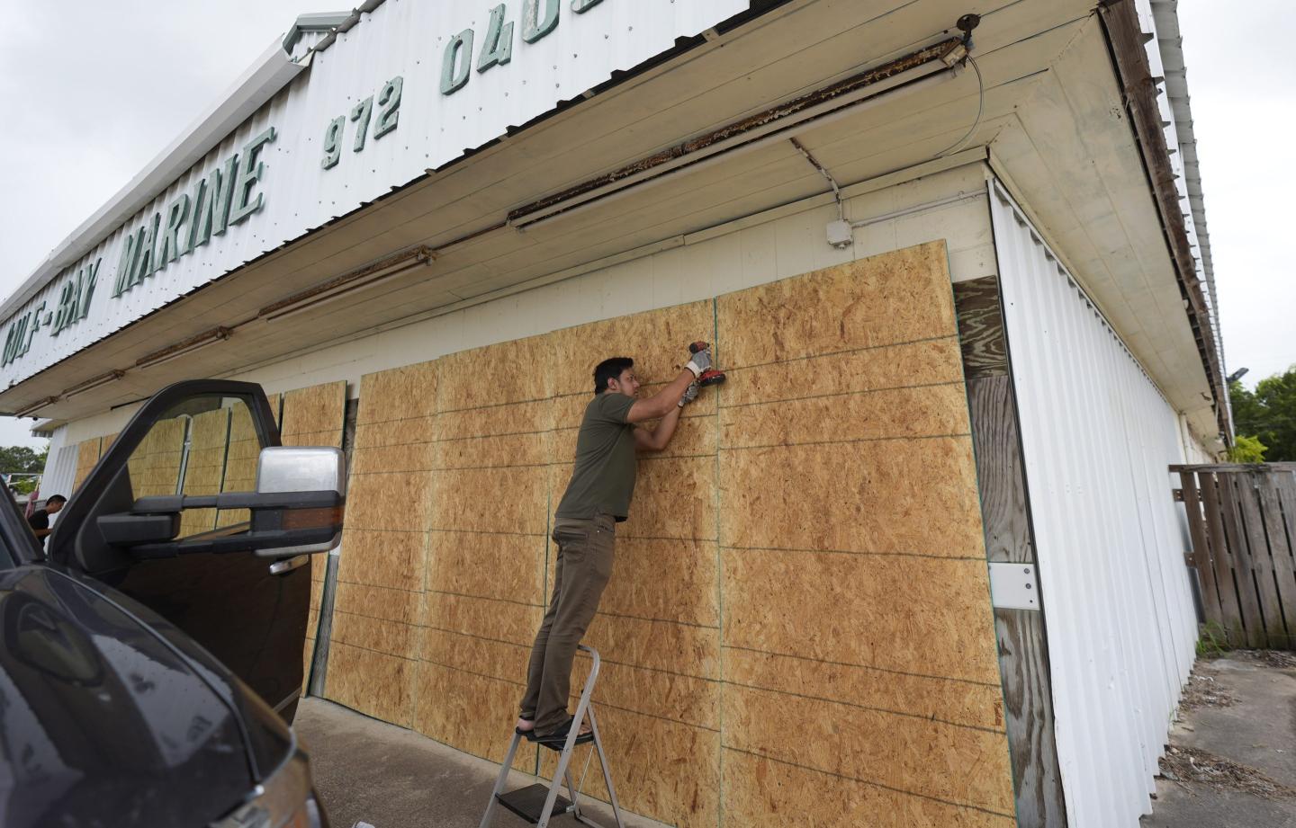 man boards up windows