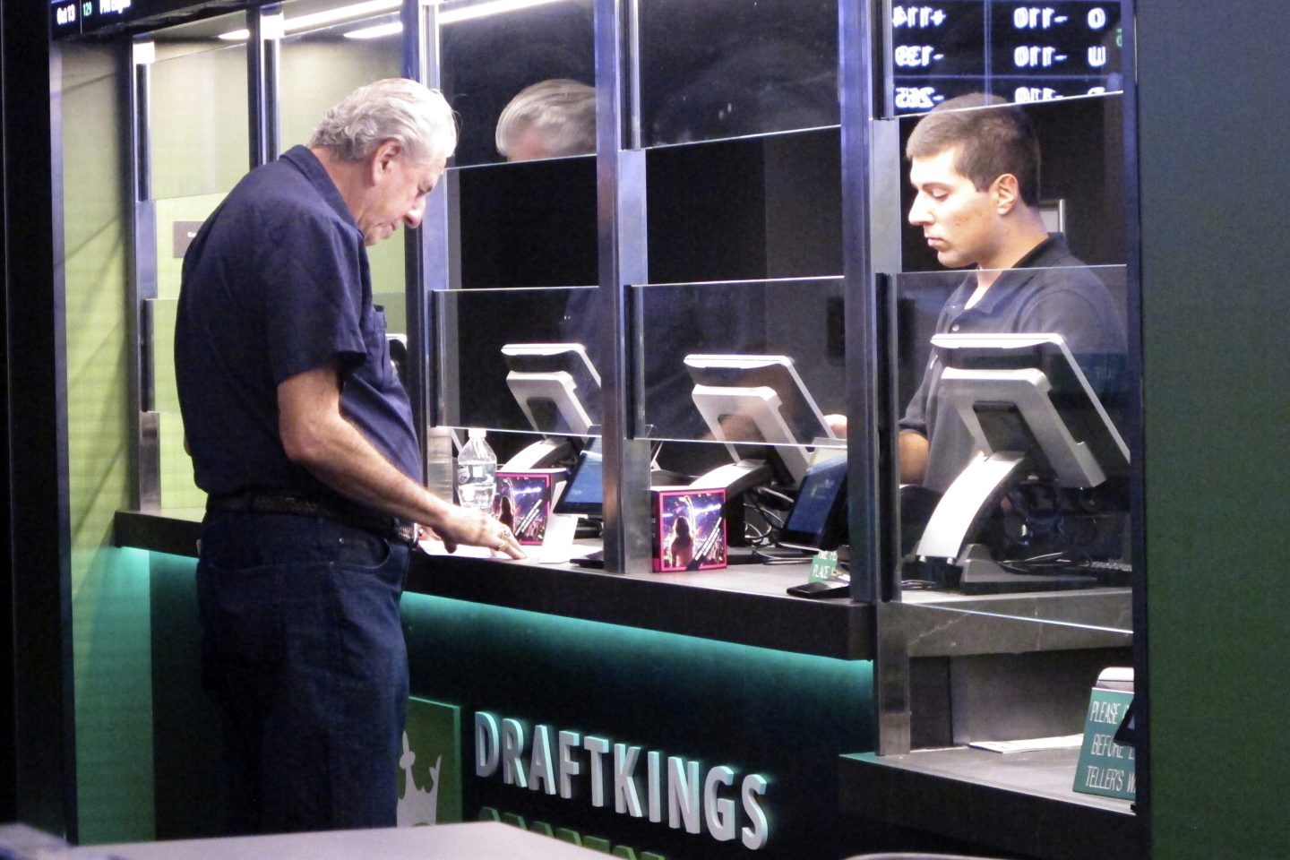 A man stands at a booth to place bets on sports