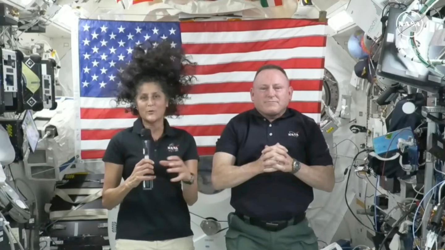 Two astronauts floating inside the ISS