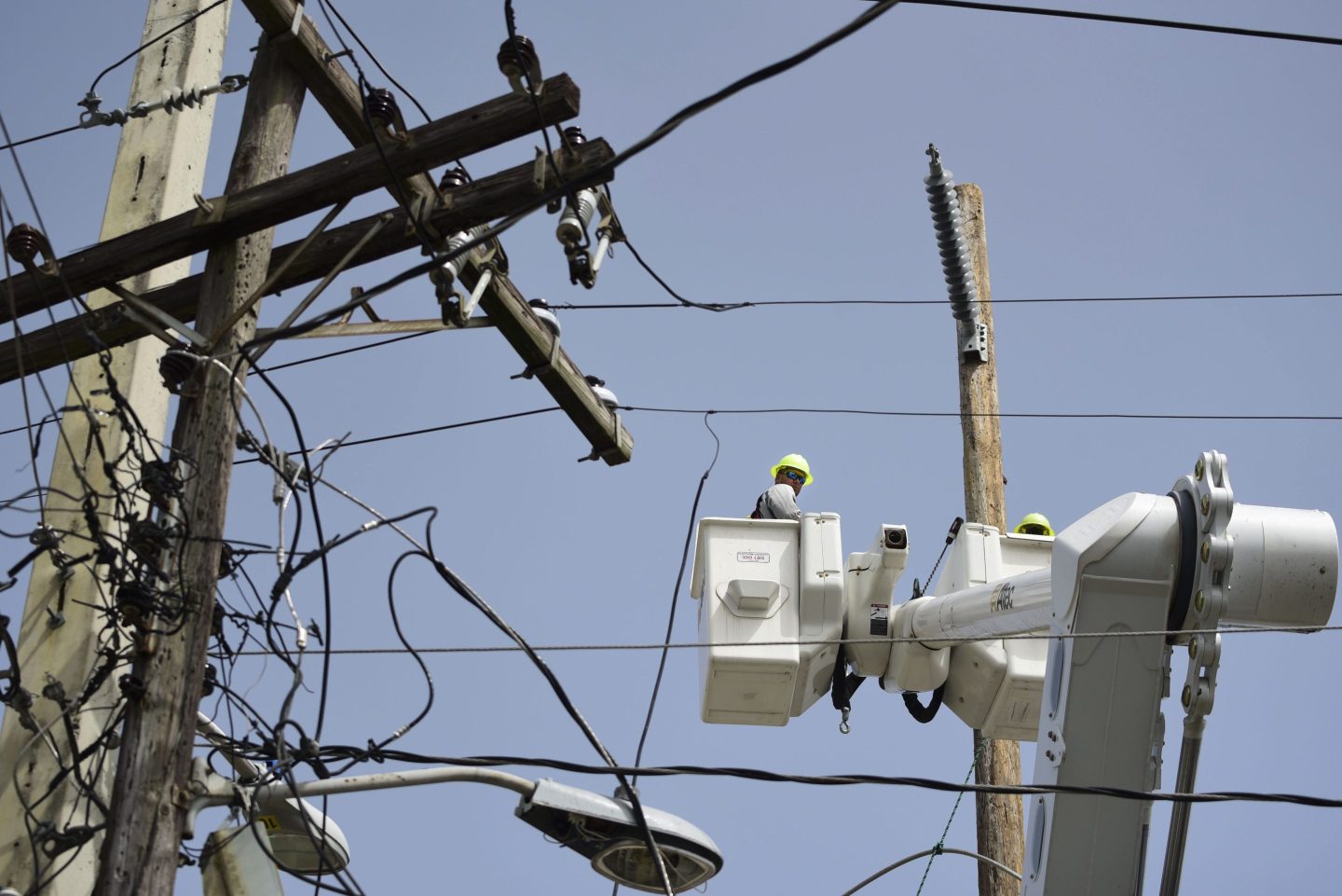 A brigade from the Electric Power Authority repairs distribution lines damaged by Hurricane Maria in the Cantera community of San Juan, Puerto Rico, Oct. 19, 2017.