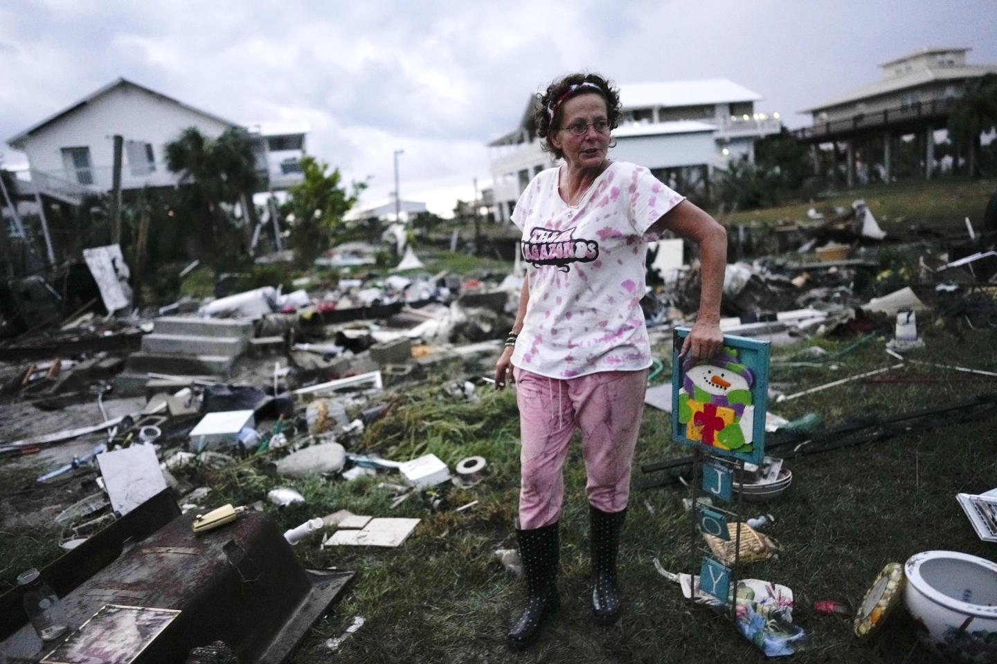 Florida resident stands in the debris after a hurricane ripped through her town