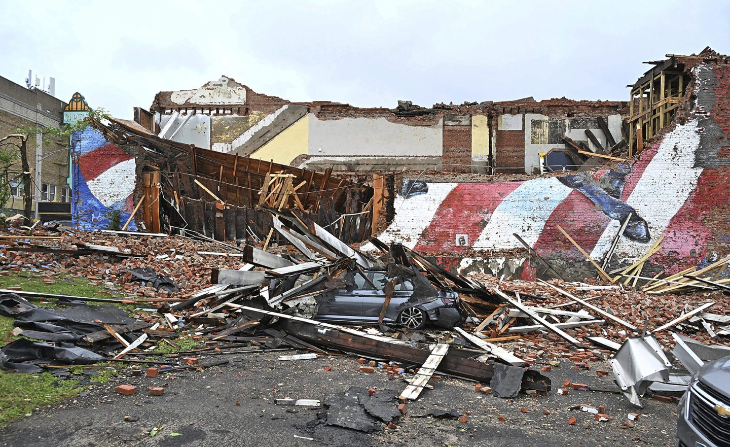 A car is crushed by the fallen building that hosted the Gansevoort mural that was struck by a tornado, in Rome, N.Y., on July 16, 2024.
