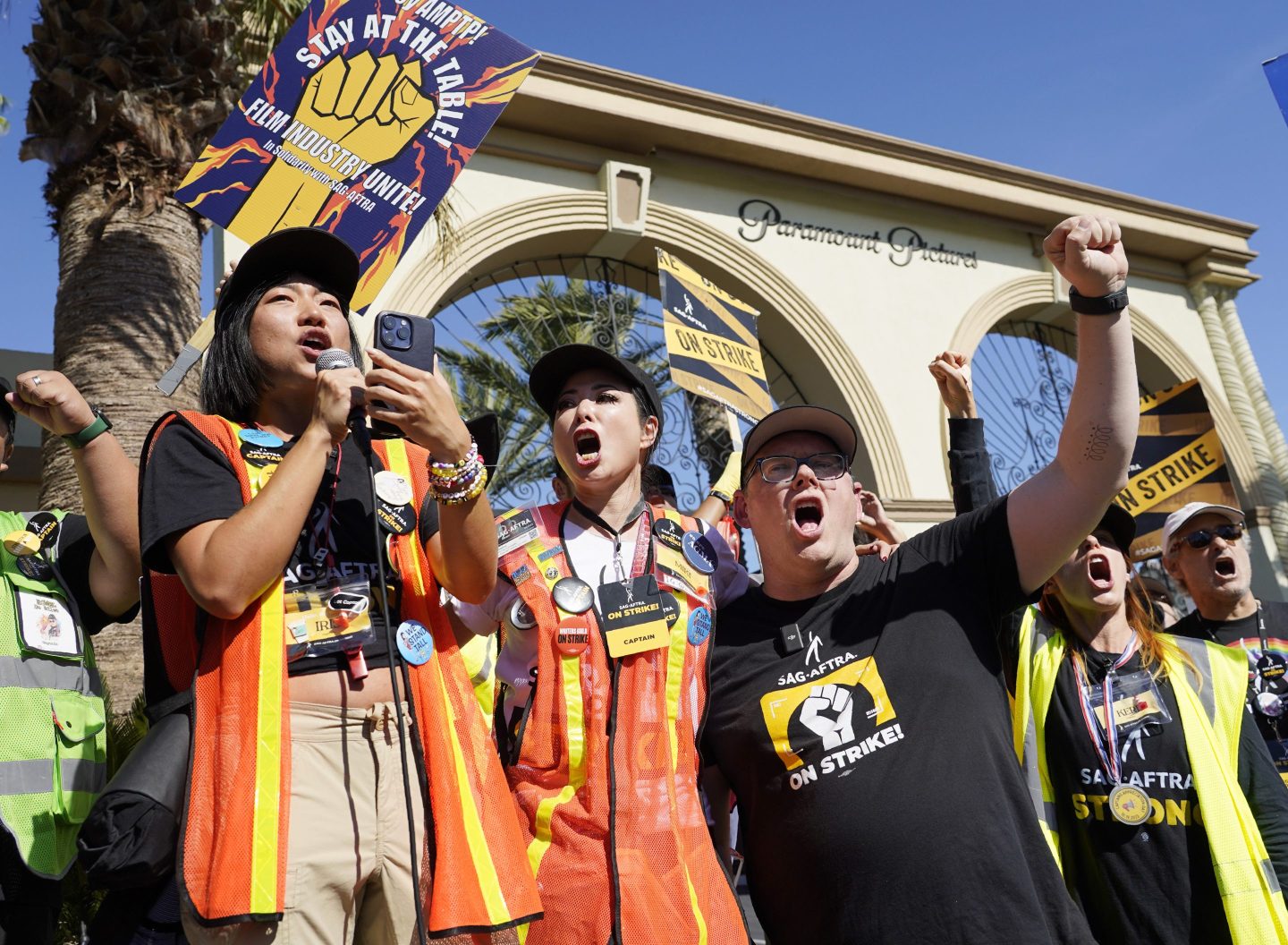 SAG-AFTRA captains Iris Liu, left, and Miki Yamashita, center, and SAG-AFTRA chief negotiator Duncan Crabtree-Ireland lead a cheer for striking actors outside Paramount Pictures studio, Nov. 3, 2023, in Los Angeles.