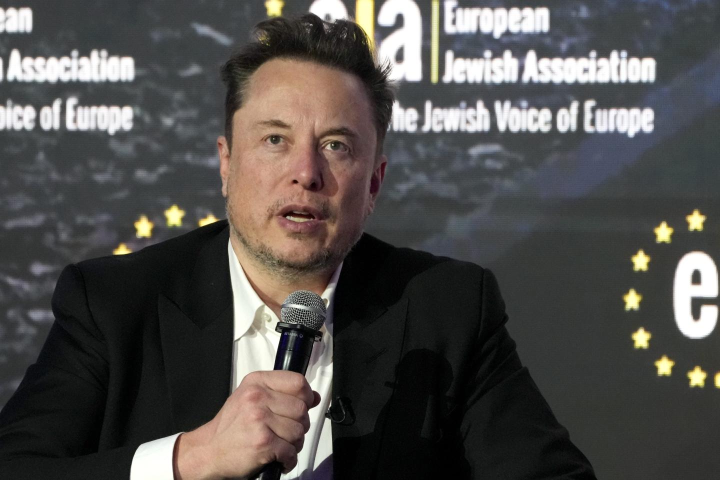 Elon Musk holds microphone