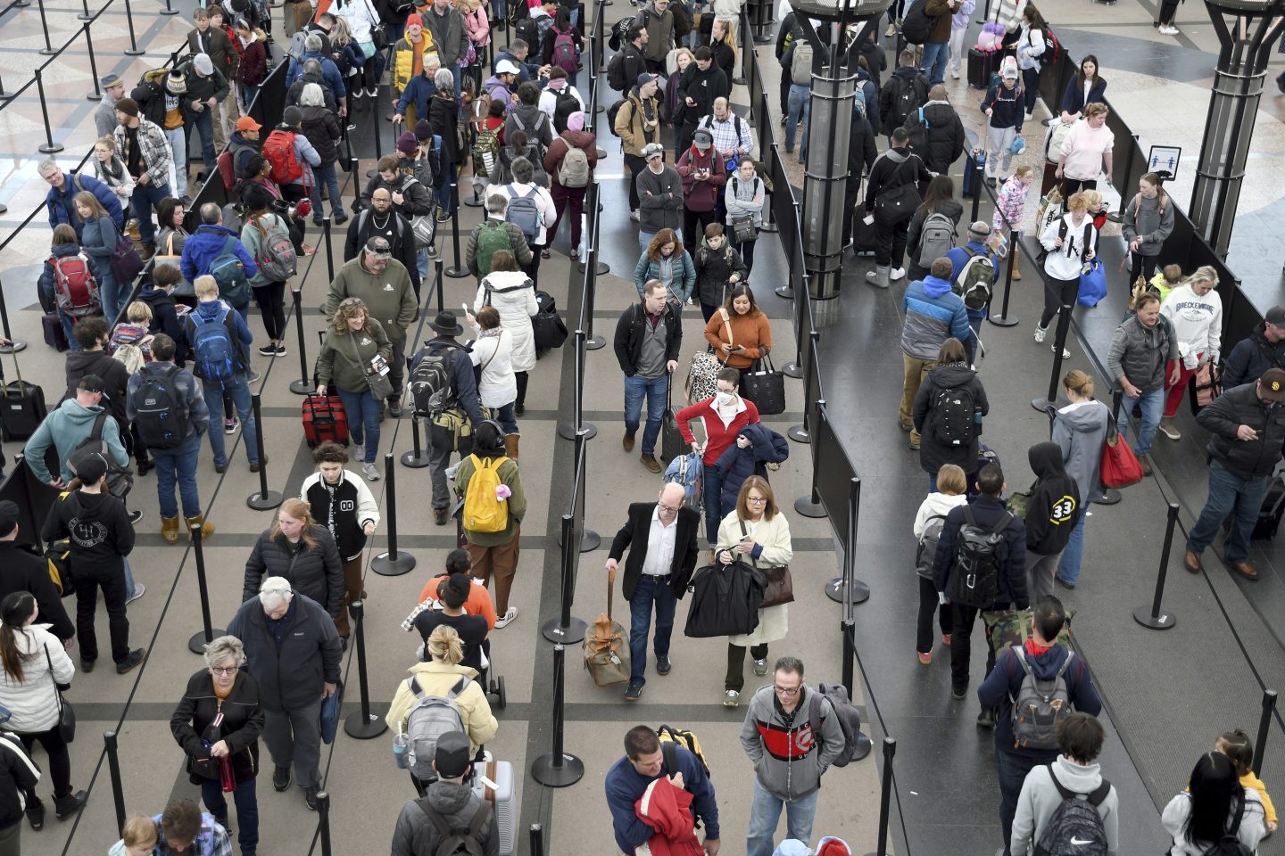 Passengers wait in a security line at Denver International Airport on Feb. 22, 2023.