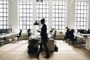A woman walks past her colleagues in a spacious open office.