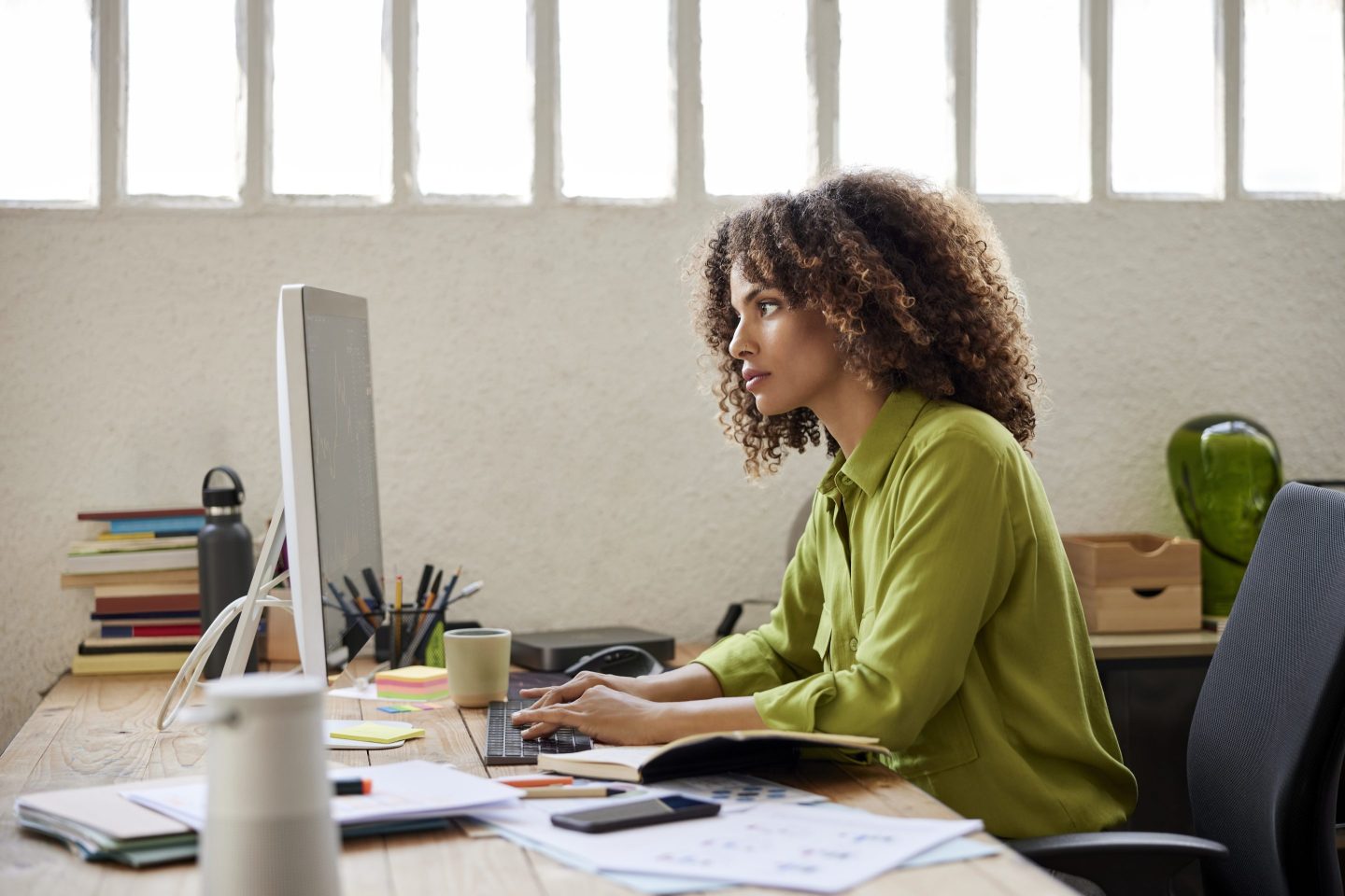 A woman typing at her computer in her home office.