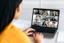 A woman attends a virtual work meeting on her laptop.