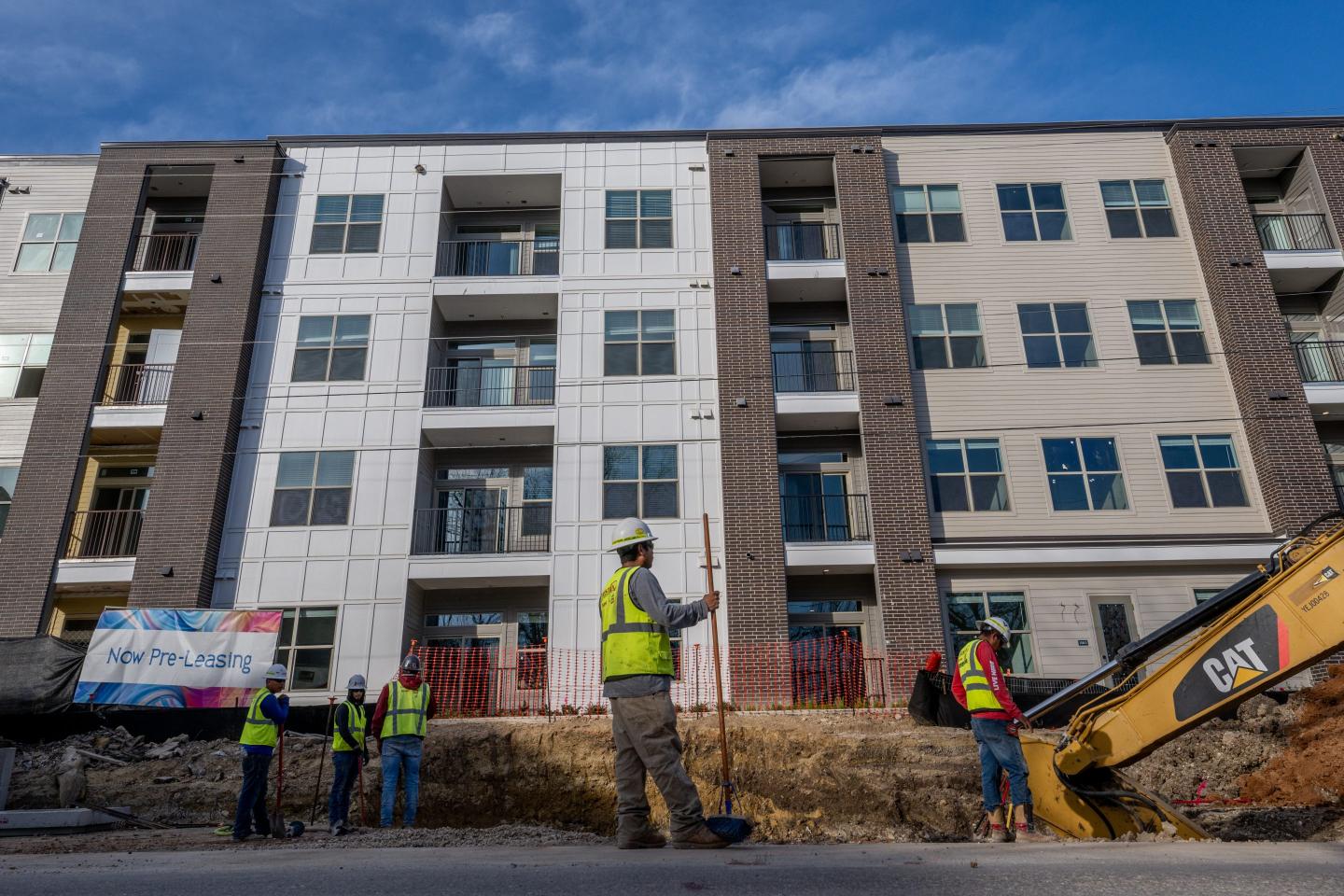 builders standing outside new apartment building