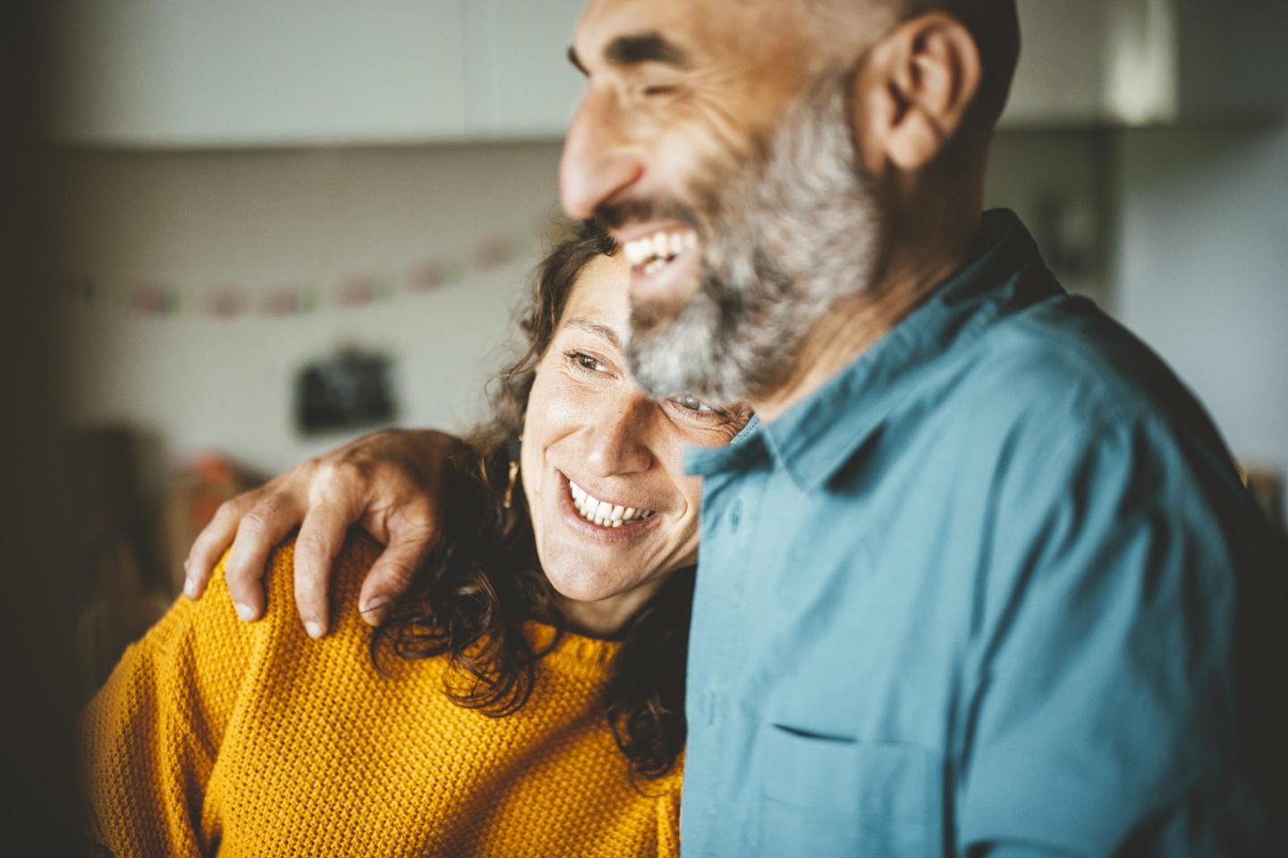 a lady smiling with her head tilted on a man's shoulder